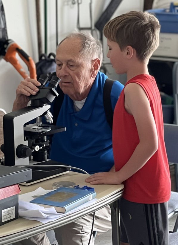 Dick with his grandson at the microscope